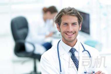 英俊的男醫(yī)生微笑與雙臂交叉在胸前肖像