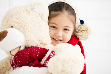 快樂的小女孩抱著玩具熊 照片