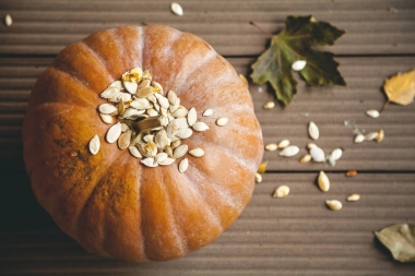 圆橙色南瓜和叶子在板上。从上面查看