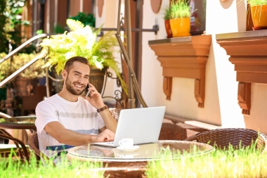 英俊的男人用的笔记本电脑  