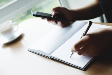 女性手持筆和電話圖片