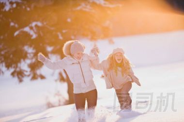 女兒在雪中奔跑的婦女圖片
