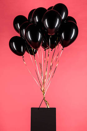 挂在黑色气球上的购物袋