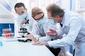 化学家使用显微镜和讨论图片