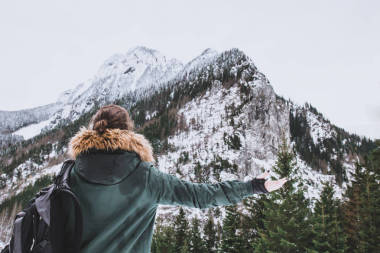 女孩看著白雪覆蓋的山