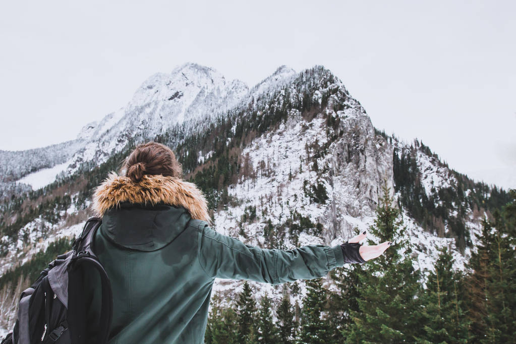 女孩看着白雪覆盖的山