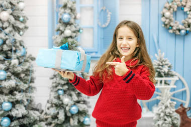 快樂的孩子收到一個禮品盒。概念新年, 快樂 Christm