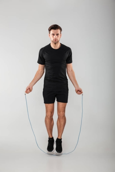 強(qiáng)的年輕體育男子跳躍跳繩圖片