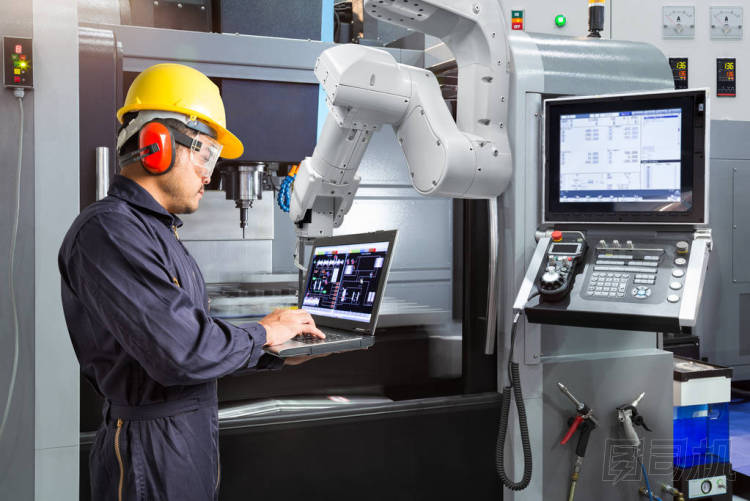 維修工程師使用筆記本電腦控制自動機械手與 Cnc 機器在智能工廠。行業(yè)4.0 理念