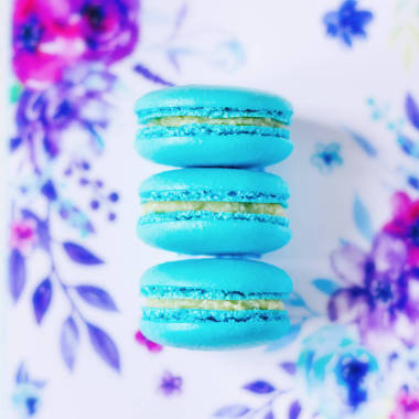 美味的三藍(lán)色馬卡龍?jiān)谝粋€(gè)神奇的花朵背景。美味