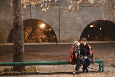 有吸引力的夫妇，在爱的怀抱，享受亲密的时刻在一起，城市的灯光背景
