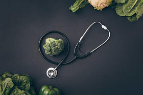 灰餐桌上的花椰菜和花椰菜的听诊器的顶部视图