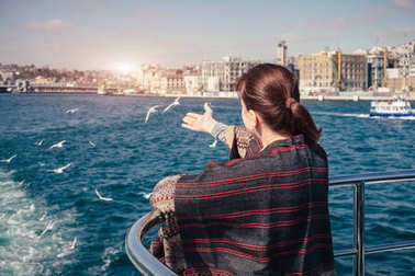 婦女旅行和到達(dá)的海鷗從輪渡在博斯普魯斯海峽