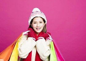 穿着冬衣和买圣诞礼物的快乐女人