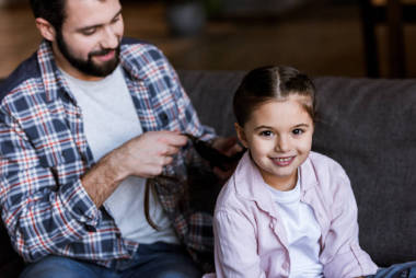 父親在家里給女兒做辮子