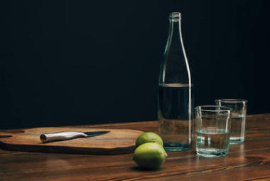 木制餐桌用刀、酸橙、瓶装水的木板