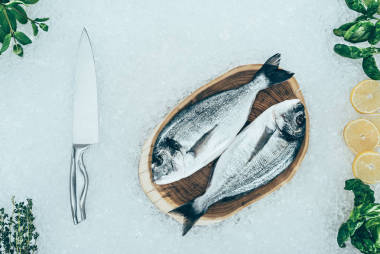 在冰上的原料魚(yú)和刀的頂部視圖