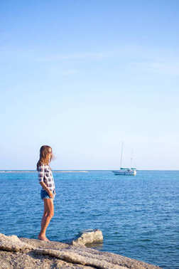 蓝色海背景的年轻女孩。热带国家。游艇在背景