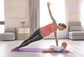 年轻的母亲在家做瑜伽与婴孩图片