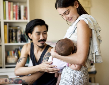 在室内，原来年轻快乐的父母抱着他们刚出生的婴儿一起影 