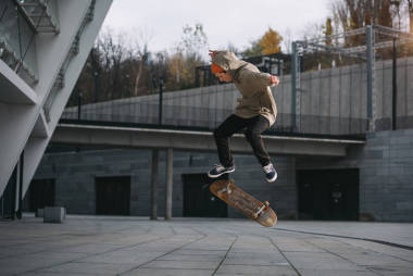 服飾服裝中的滑板在城市位置表演跳躍技巧