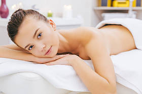 美丽的年轻女子在 spa 按摩台上放松