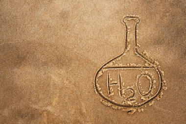 油漆瓶和水在沙子上的化学公式。海滩和海洋的水质