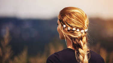 带花圈和辫子的嬉皮女孩在室外背面视图