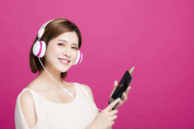 女人聽音樂耳機(jī)與智能手機(jī)圖片