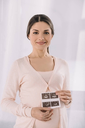 手持超声诊断照片的快乐孕妇