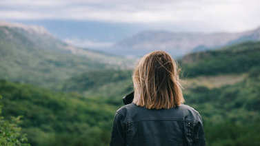 美麗的女孩在山頂看風(fēng)景