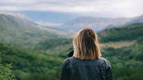 美丽的女孩在山顶看风景
