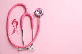 粉红色的丝带和听诊器的颜色背景。乳癌概念