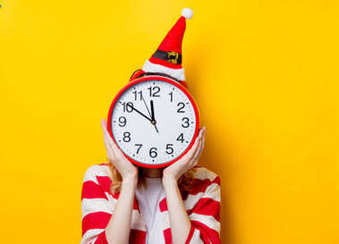 戴着钟的圣诞老人帽子的女人