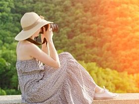 戴着帽子的女孩拍照背景下的绿色森林