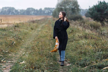 農村站在路上的年輕女子。秋天, 多云天氣