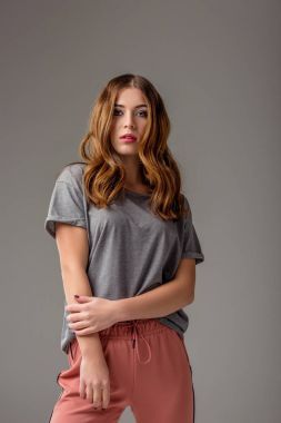 時(shí)尚體貼的女人肖像看著相機(jī)孤立在灰色