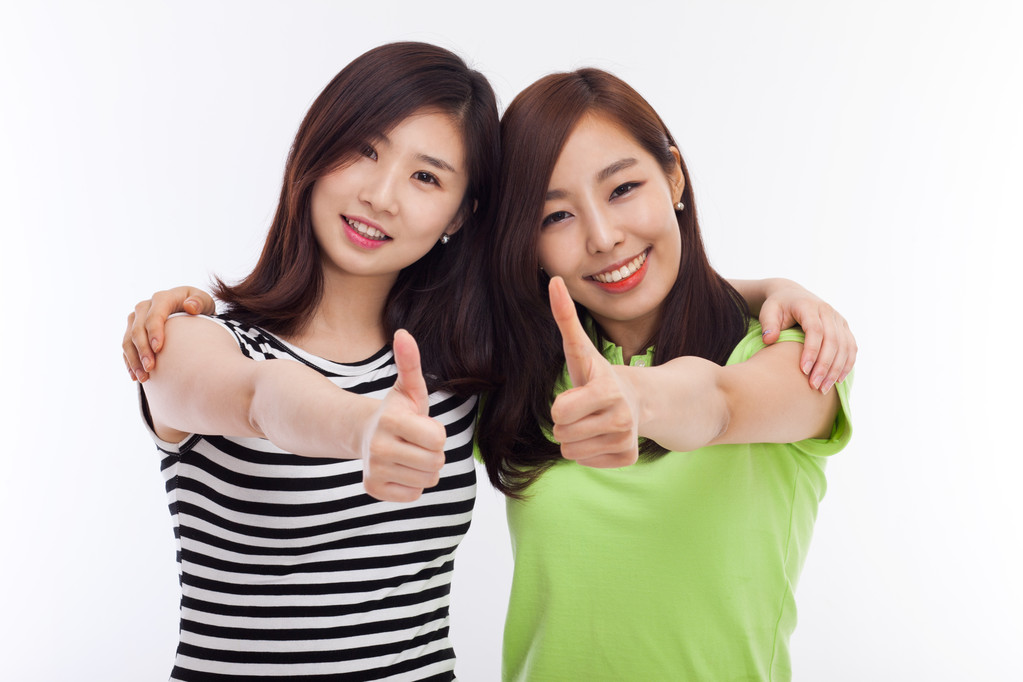 年轻的亚裔女子显示拇指