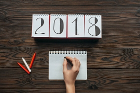 用铅笔写字的女性在木制桌面上的部分视角