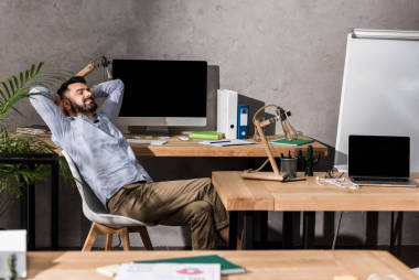 在办公室椅子上放松的英俊的生意人