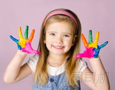 微笑著用手在油漆的小女孩