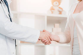 医生和病人在临床上握手的镜头