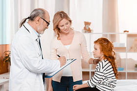 在诊所接受治疗时在记事本上做笔记的资深医生