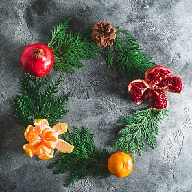 树枝, 美味的柑橘和石榴在黑暗的背景。新的一年概念, 复制空间。平躺。顶部视图