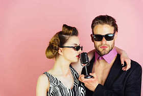 戴眼镜的情侣在麦克风里唱