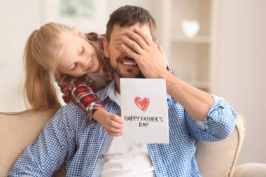 逗人喜愛的小女孩問候她的爸爸在父親的天在家