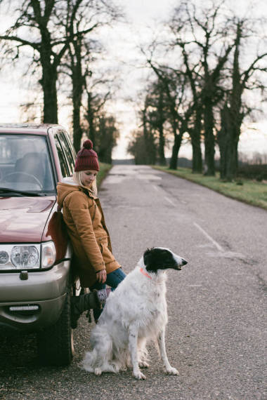 帶著狗一個女人帶著她的狗旅行在路上等待越野車