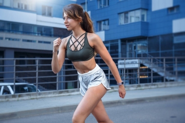 長發(fā)運(yùn)動的女孩在時尚的銀色短褲和深綠色的 t-shirt 是在城市背景下運(yùn)動。這張照片是在一個可愛的夏日清晨 durring 的日出