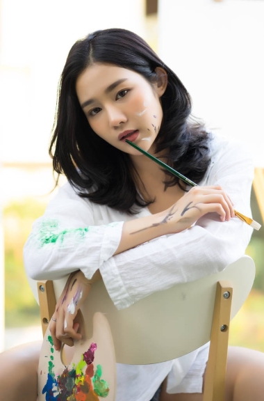 美麗的年輕女子在椅子上坐在因果的衣服 