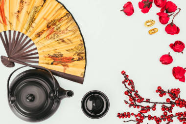 中國(guó)新年的頂部觀茶和手持式風(fēng)扇隔離在白色